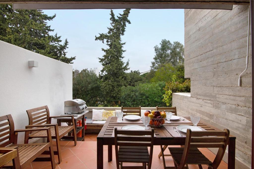 an outdoor patio with wooden tables and chairs at Apartamento Balaia Praia in Albufeira