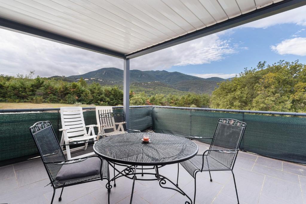 a table and chairs on a patio with a view at Gîte F2, Dans Un Coin De Paradis in Céret