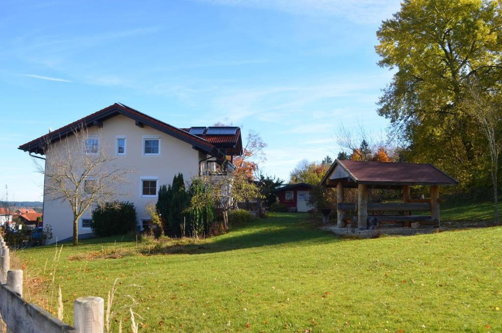 a white house and a gazebo in a yard at Ferienwohnung Am Schlössle in Lechbruck