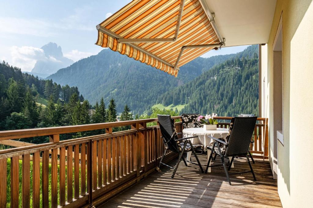 Un balcón con mesa y sillas con vista. en Salman, en Ortisei