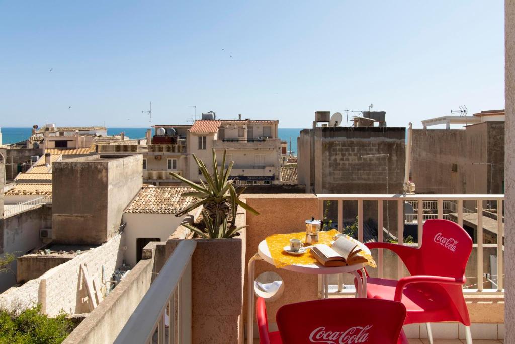 a table and chairs on a balcony with a view at Casa Riviera in Donnalucata