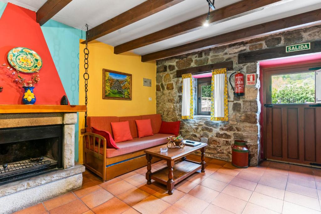 a living room with a couch and a fireplace at Lorences A in Caunedo