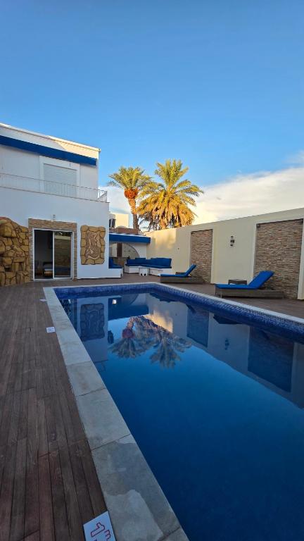 a swimming pool in front of a house at dar saoussen in Triffa