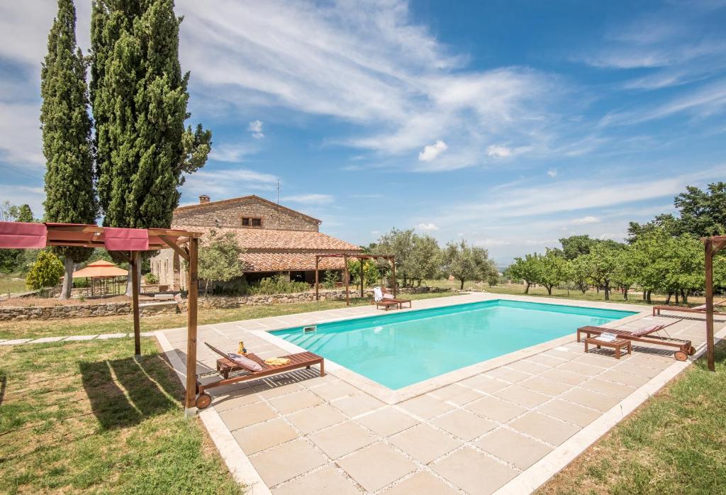 サルテアーノにあるTenuta Podere Montemelinoのベンチ2台付きの庭のスイミングプール