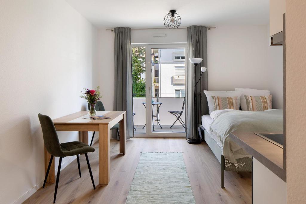 a bedroom with a bed and a desk and a table at Ferienwohnung Münster, sehr zentral in Freiburg im Breisgau
