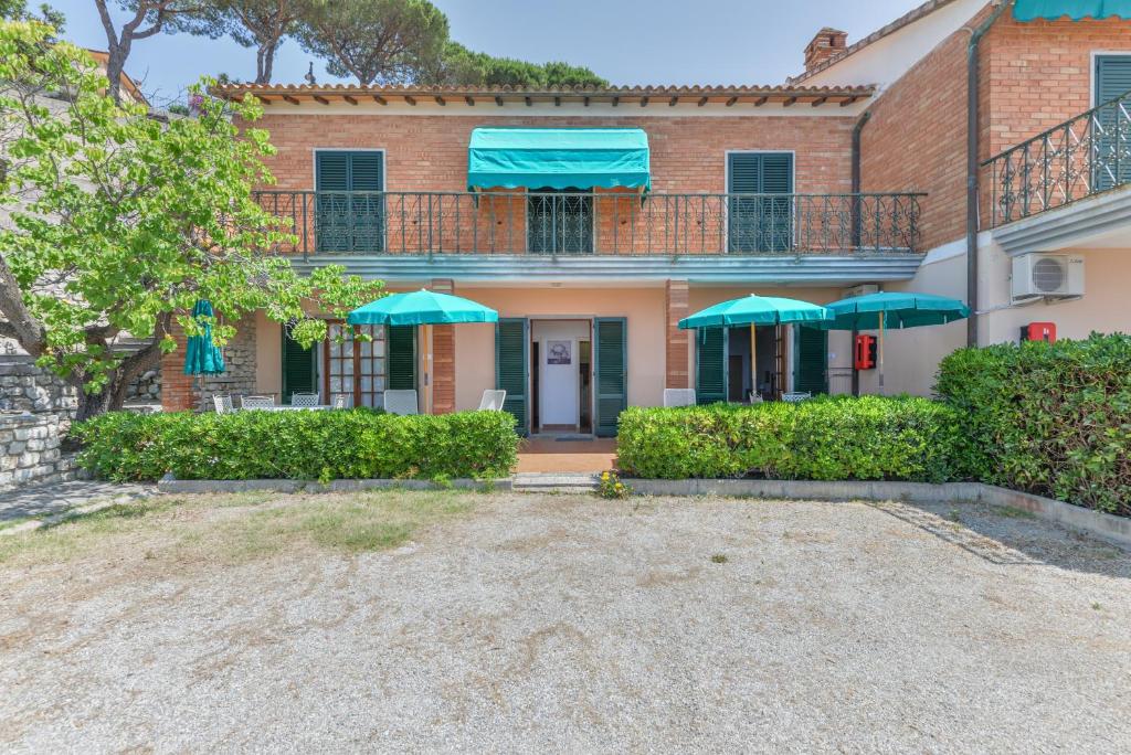 a house with a balcony with green umbrellas at Capoliveri: Villa Lorena 1 (bilocale) in Capoliveri
