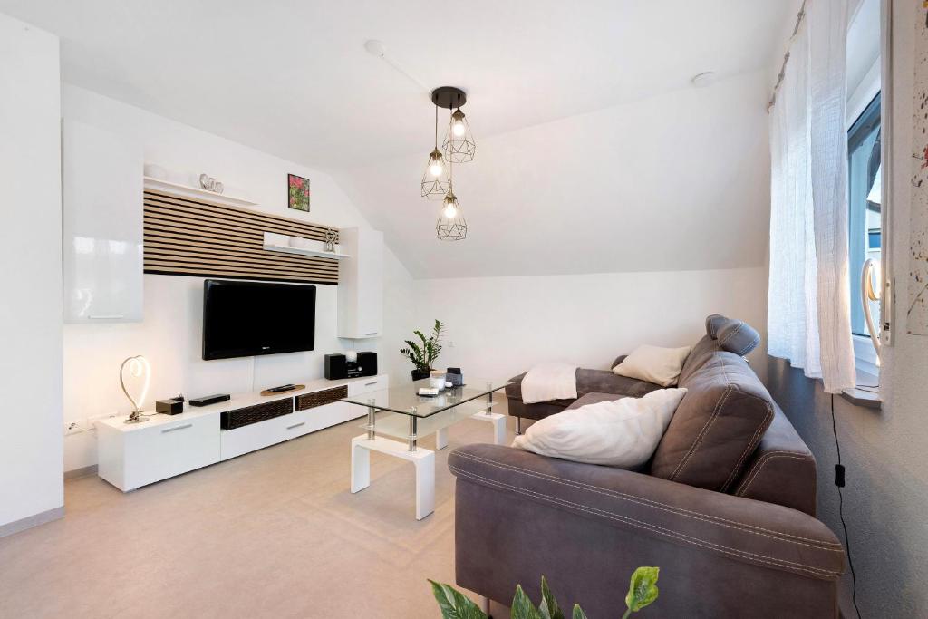 a living room with a couch and a tv at Ferienwohnung Rosengarten in Mössingen