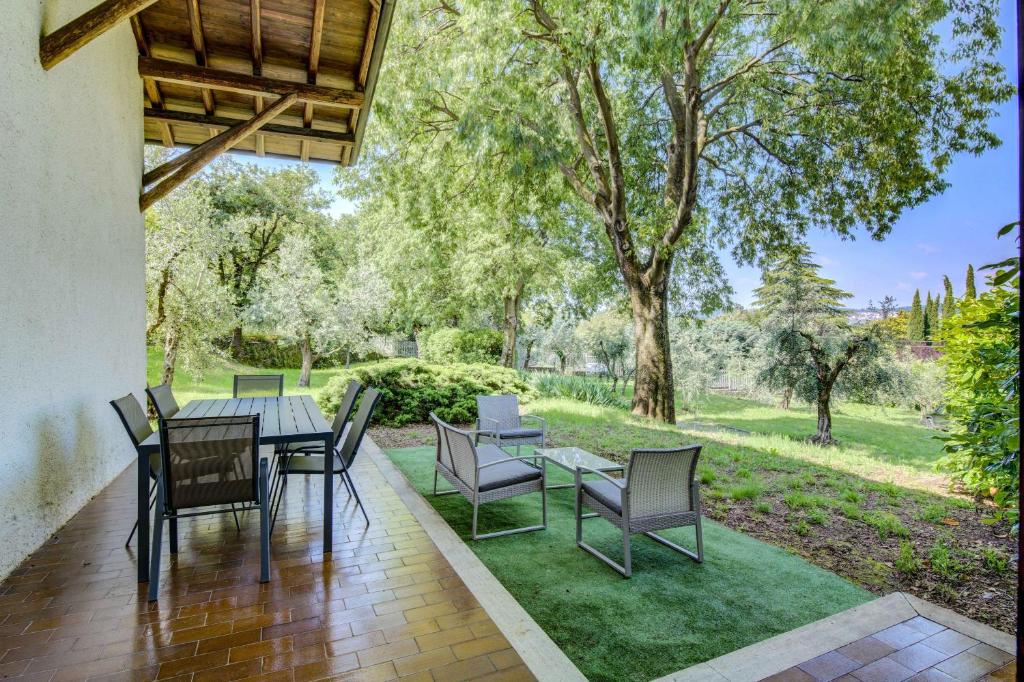 a patio with a table and chairs on a lawn at Appartamento Rupestre in Manerba del Garda