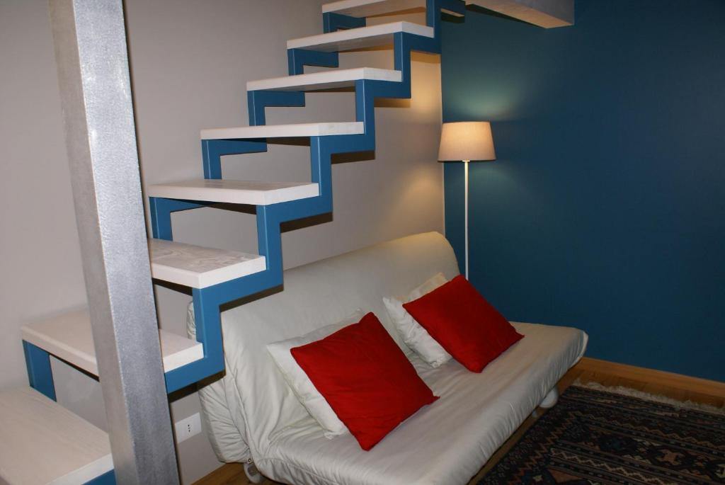 een kamer met een bank en een blauwe en witte trap bij Studio Sforzesco in Bellinzago Novarese