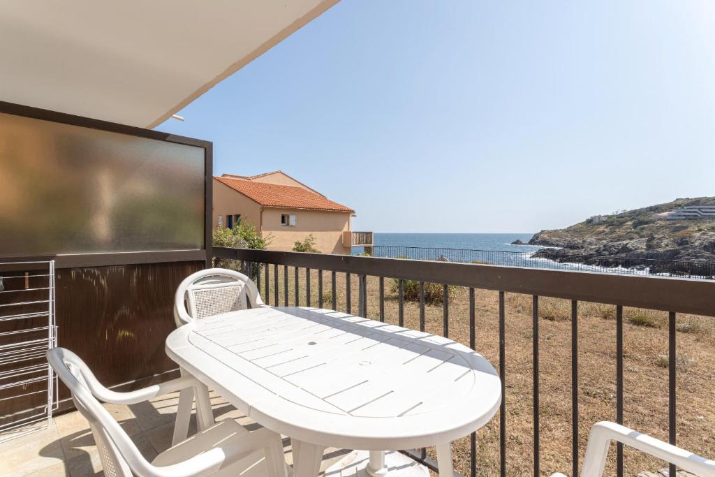 コリウールにあるAppartement terrasse vue merの白いテーブルと椅子、海を望むバルコニー