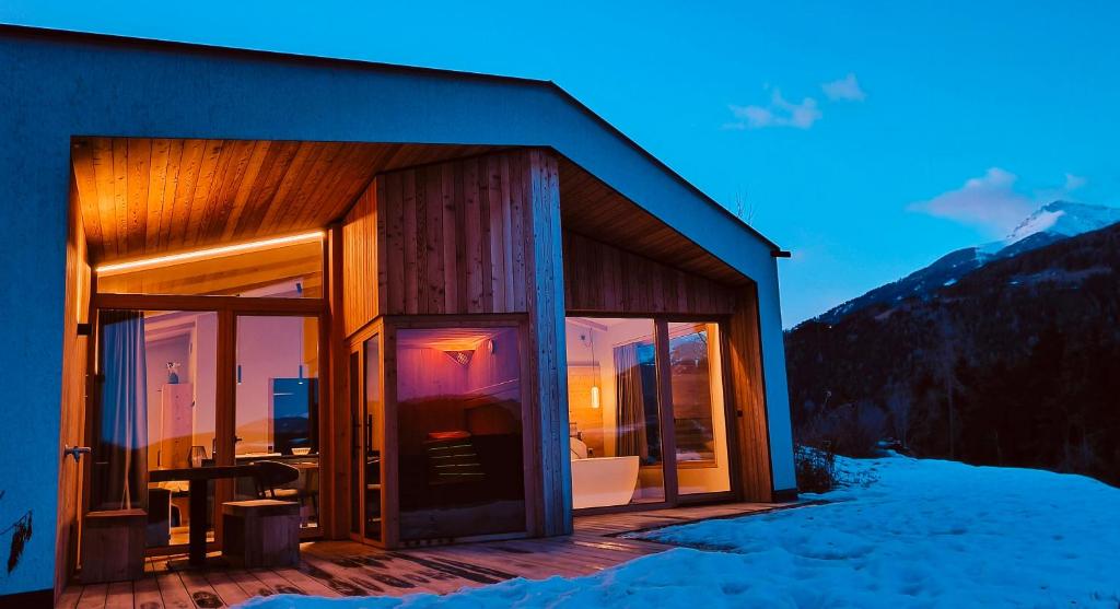 una casa con porte scorrevoli in vetro nella neve di Oberplunerhof Luxury Chalet Skyline a Colli in Pusteria