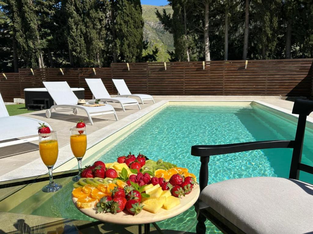 een fruitschaal op een tafel naast een zwembad bij Delux with private pool in Castellammare del Golfo