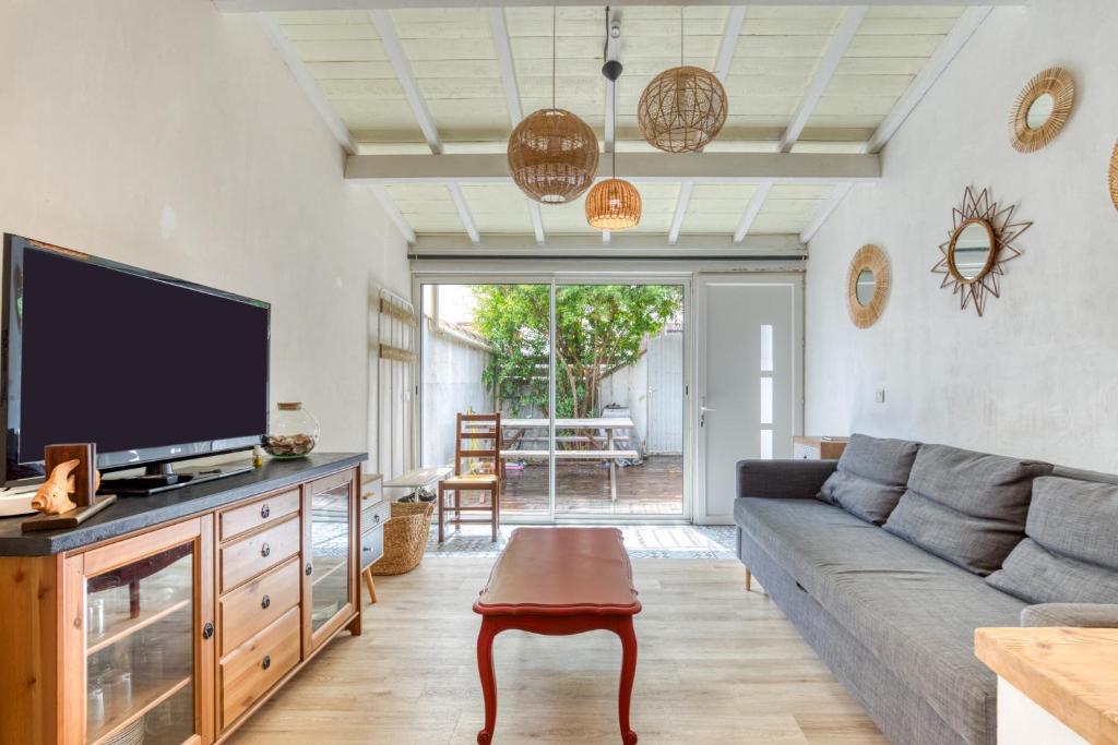 ein Wohnzimmer mit Sofa und Flachbildfernseher in der Unterkunft Maison avec terrasse climatisation in Saintes-Maries-de-la-Mer