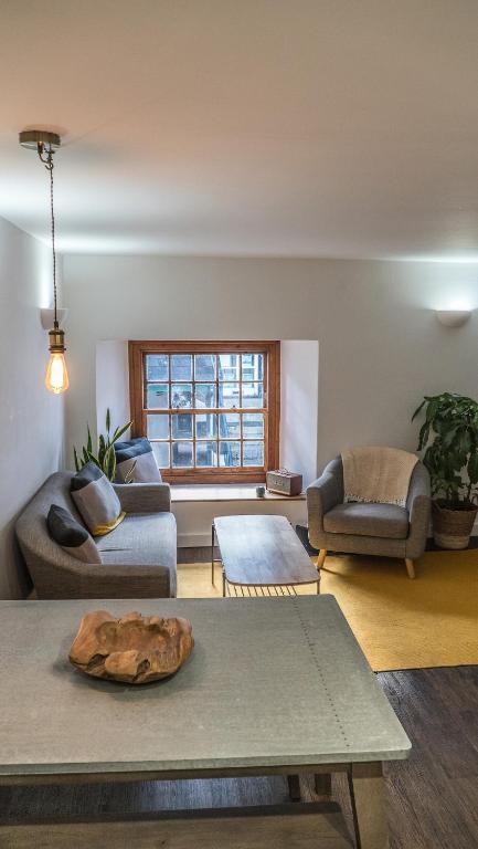 a living room with a couch and a table at Mor Ki -A perfectly situated modern flat in Looe in Looe