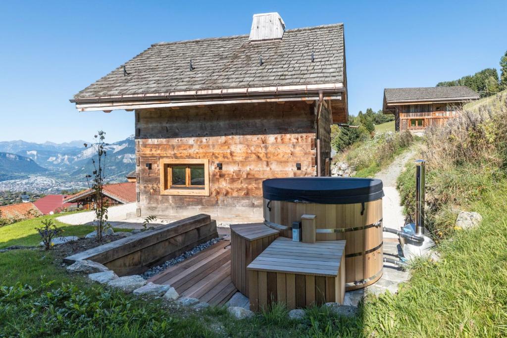 une cabane en rondins avec un banc et un tonneau dans l'établissement Mazot de la Pointe Percée, à Demi-Quartier