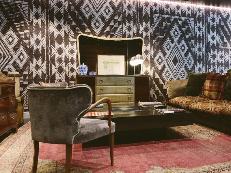 Una sala de estar con una silla y un espejo. en Aethos Milan, en Milán