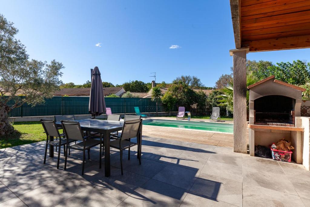 レ・ペンヌ・ミラボーにあるMaison Tout Confortのプールサイドのパティオ(テーブル、椅子付)