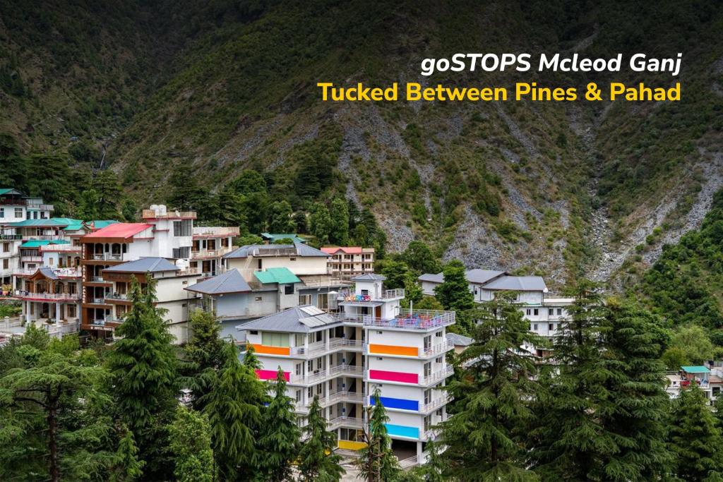 a group of buildings in front of a mountain at goSTOPS Mcleodganj, Bhagsu in McLeod Ganj