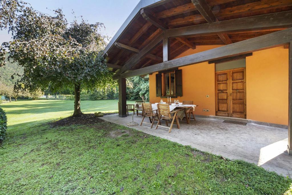 een terras met een tafel en stoelen in een tuin bij Villetta Arcadia Corallo in Vobarno