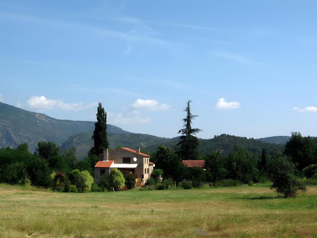 een huis in een veld met bergen op de achtergrond bij Gîte Le Chant Des Oiseaux in Sahorre