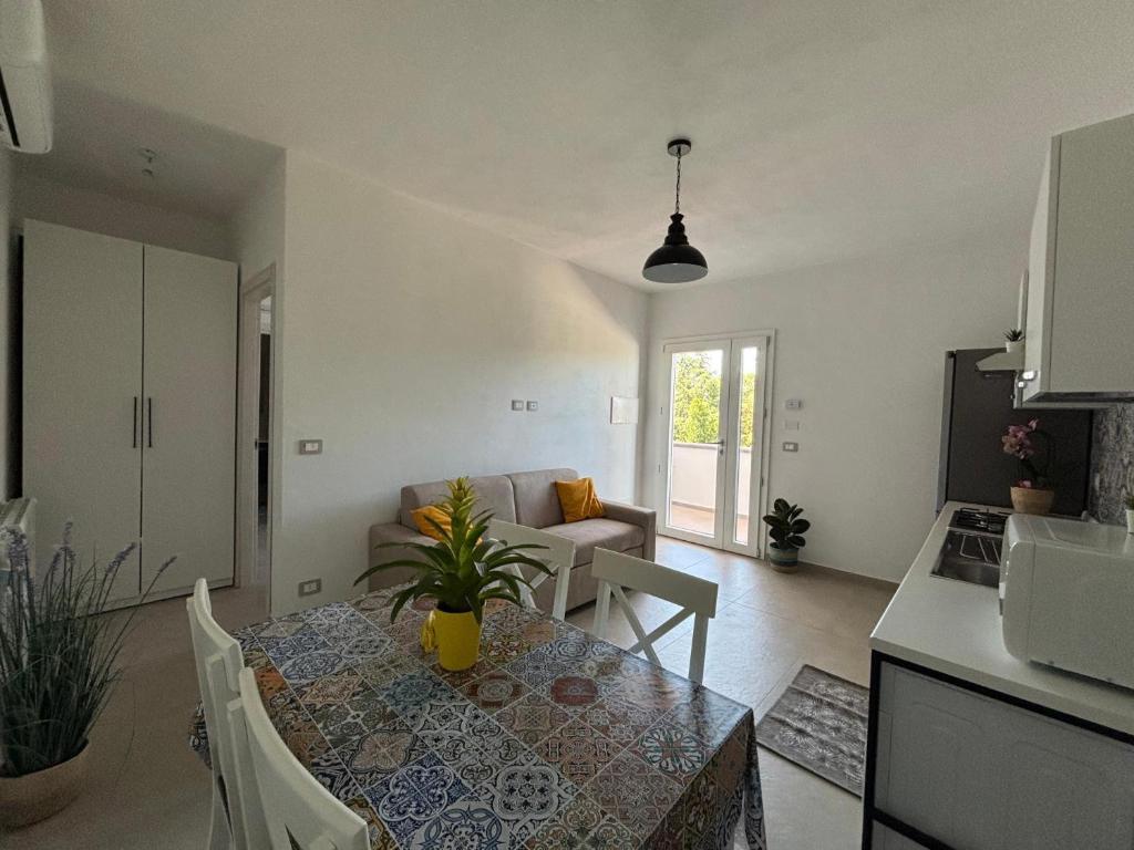 アルバタックスにあるVilla Giustina Apartment Tortolìのキッチンとテーブルのあるリビングルーム
