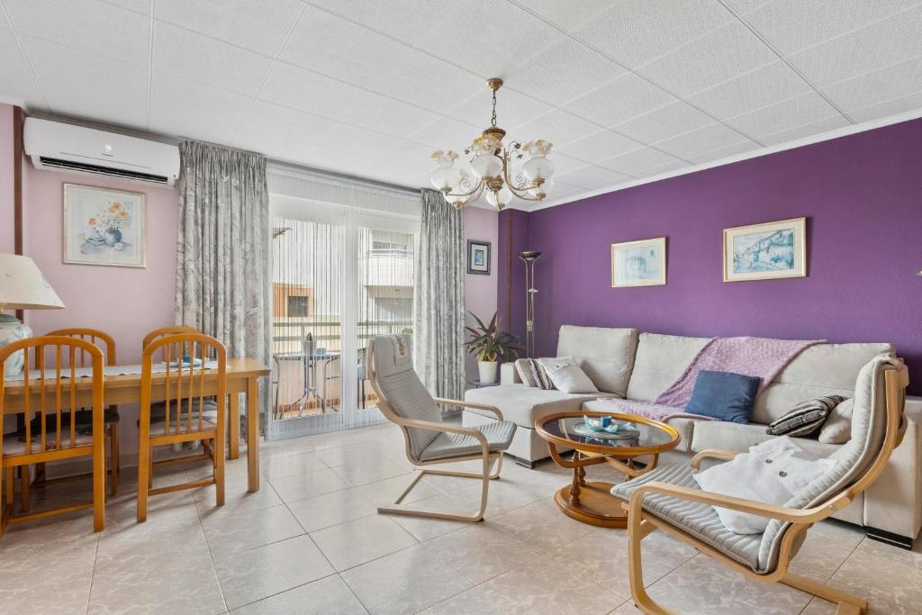 een woonkamer met paarse muren en een bank en stoelen bij Sanpolicarpo in Torrevieja