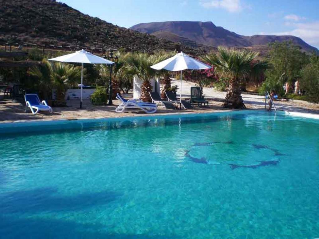 duży basen z niebieską wodą z krzesłami i parasolami w obiekcie Cortijo Torreblanca - 7 personas w mieście Almería