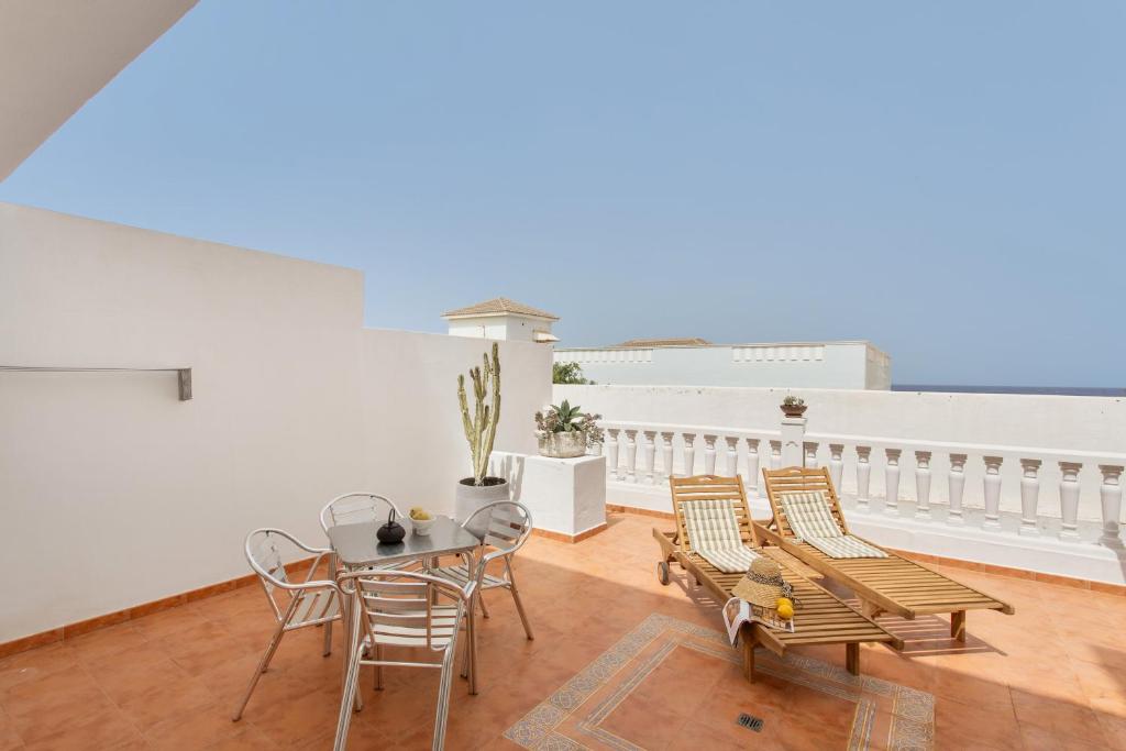 a room with a table and chairs and a balcony at Atlantic Nomad Retreat in Puerto del Rosario