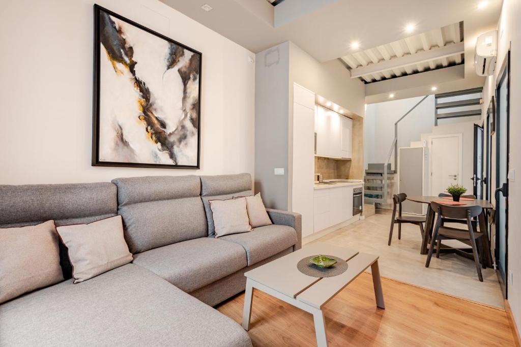 a living room with a couch and a table at Dúplex el patio en centro de Sevilla in Seville