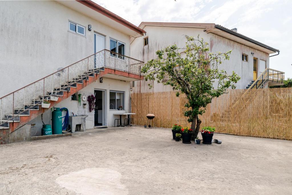 a building with a staircase and a tree in a courtyard at Casa dos Pirulitos in Apúlia