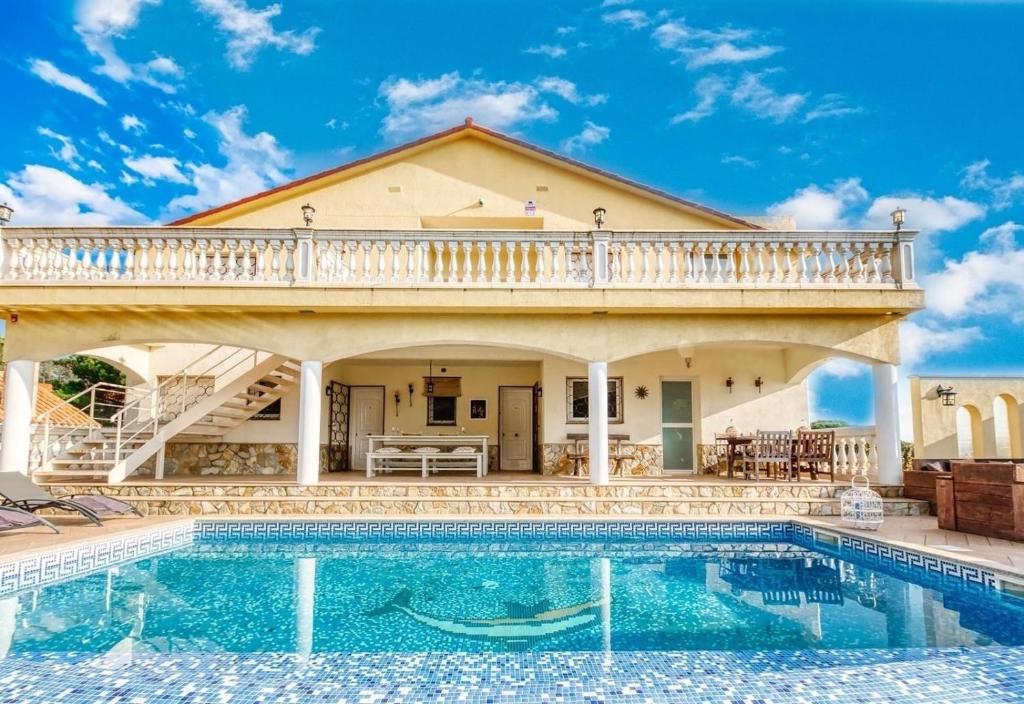 a house with a swimming pool in front of a house at Costacabana - Villa Madonna in Lloret de Mar