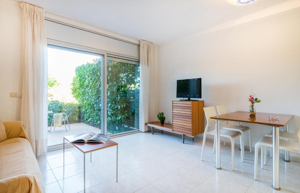 a living room with a couch and a table and a television at Apartaments Ancora in Palamós