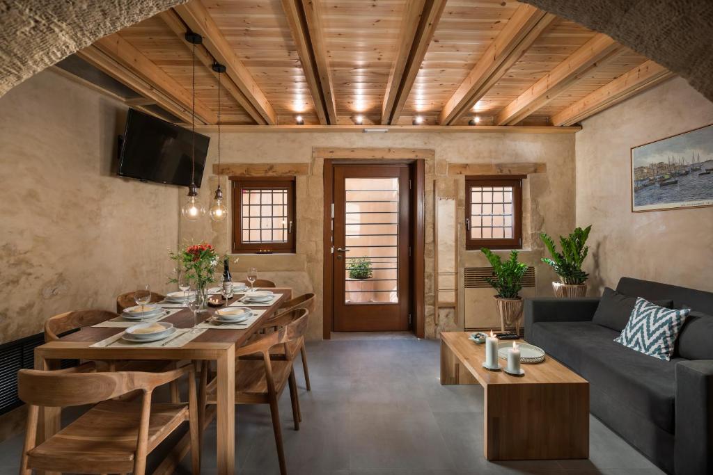 a dining room with a table and a couch at Neoria Houses in Chania