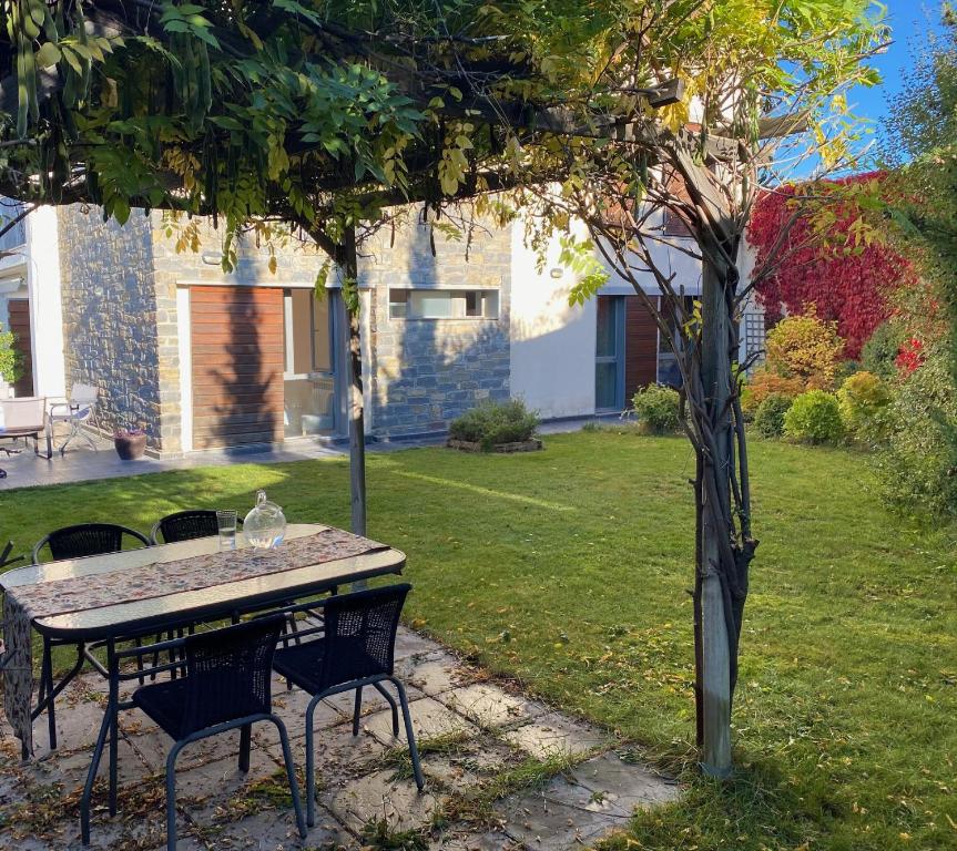 einen Tisch und Stühle unter einem Baum im Hof in der Unterkunft Jardin de los Pirineos- Margas Golf in Sabiñánigo