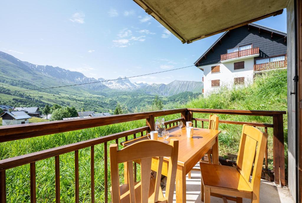 einen Tisch und Stühle auf einem Balkon mit Bergblick in der Unterkunft Neptune in Albiez-Montrond