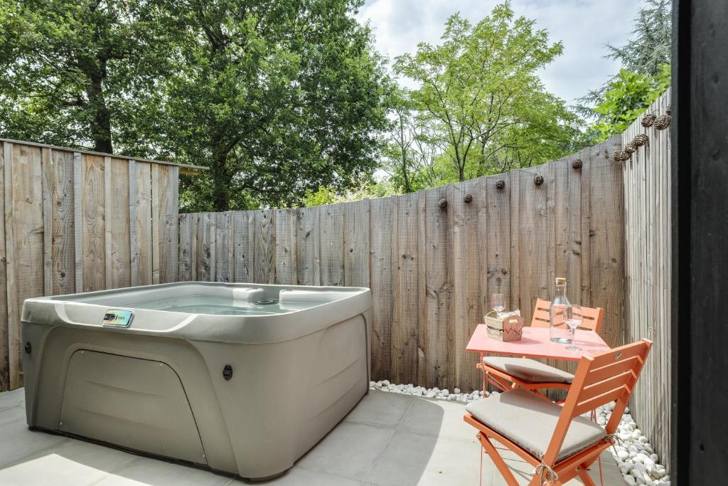 a bath tub sitting on a patio next to a fence at L'Entre 2 in Quinsac