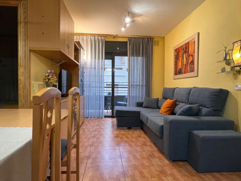 a living room with a blue couch in a room at Edificio Simancas in Sant Carles de la Ràpita