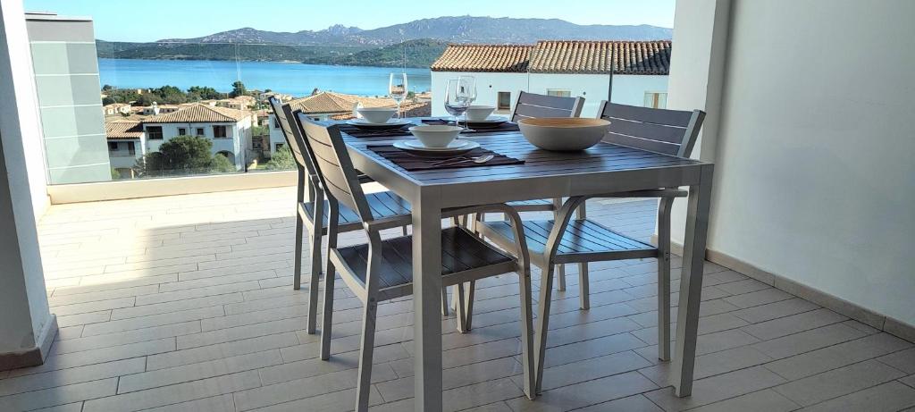 een tafel en stoelen op een balkon met uitzicht bij Atemberaubendes Familien Penthouse Mit Meerblick in Cannigione