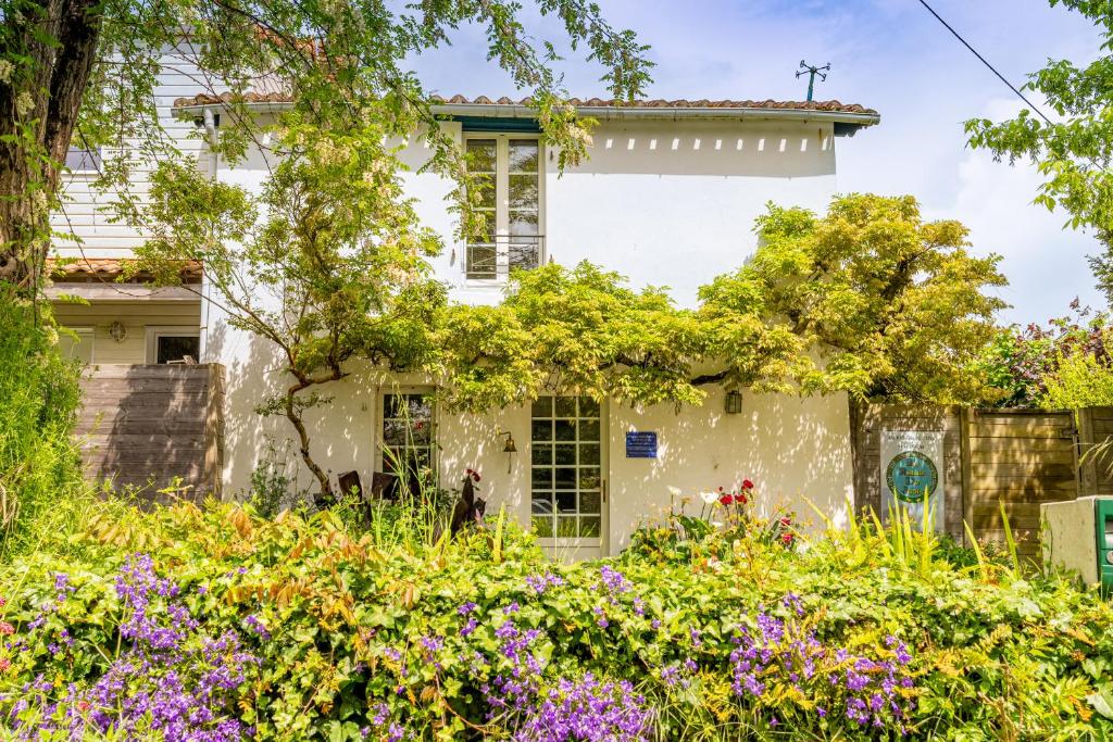 ein weißes Haus mit Blumen davor in der Unterkunft Maison De Charme - 400m plage in Pornic