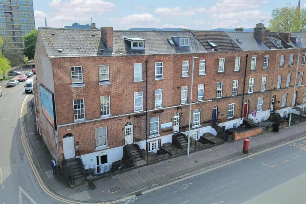 a large brick building on the side of a street at The Albert Hotel in Gloucester