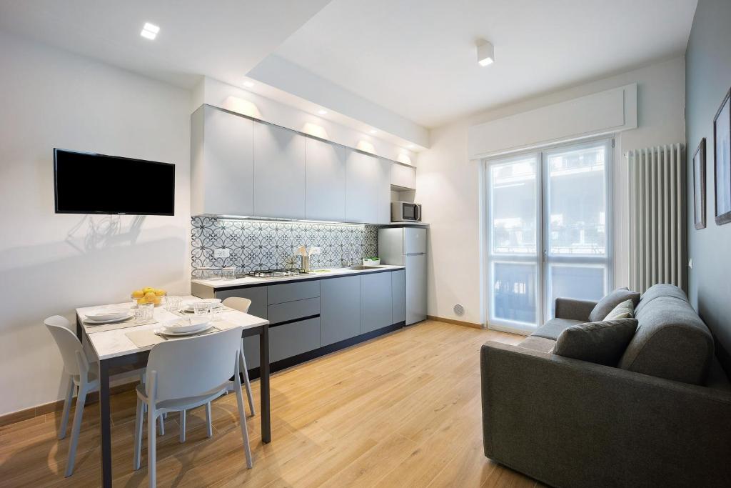 une cuisine et un salon avec une table et un canapé dans l'établissement Victoria Apartments Family, à Diano Marina
