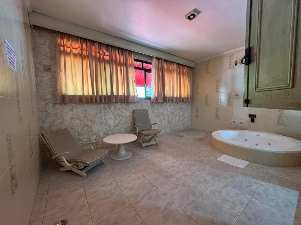 y baño con bañera, mesa y sillas. en Flats Ponte Pênsil, en São Vicente