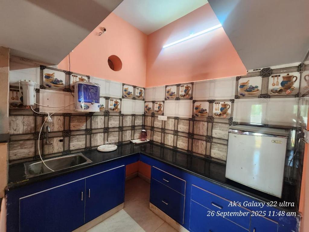 a kitchen with blue cabinets and a sink at Le homestay villa in Puducherry