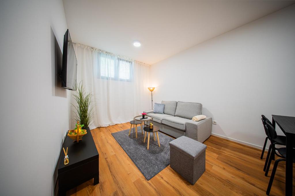 een woonkamer met een bank en een tafel bij Flex SelfCheckIns 188 - Zagreb - 2 Bedrooms - Parking in Zagreb