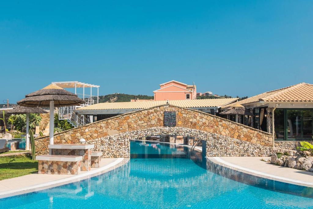 une grande piscine avec un pont et un bâtiment dans l'établissement Mirage Arillas Studio Type A10, à Arillas