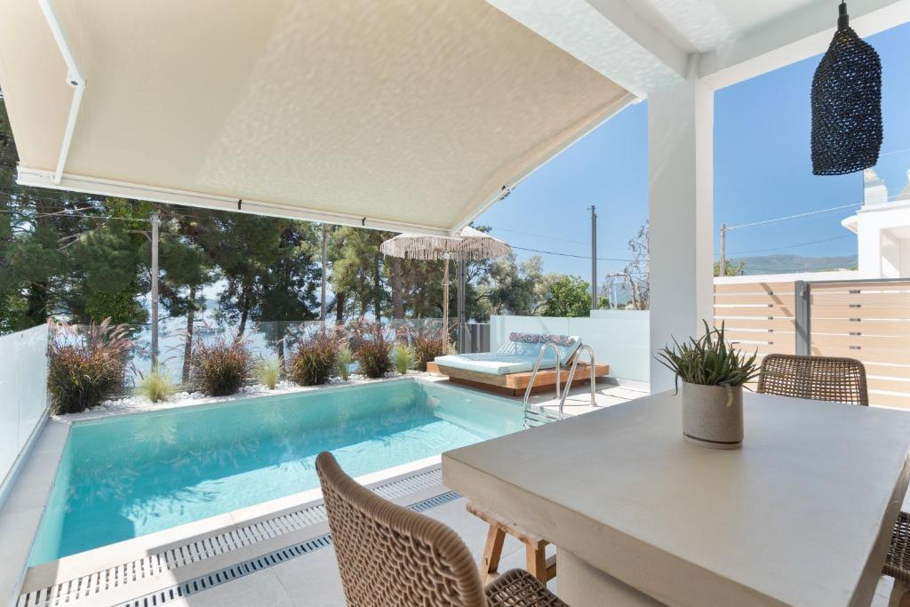 a patio with a table and chairs and a swimming pool at Mella Roa - Villa Onyx in Nydri