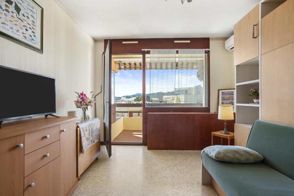 un salon avec un canapé et une télévision dans l'établissement Résidence Athena vue mer, à Bormes-les-Mimosas