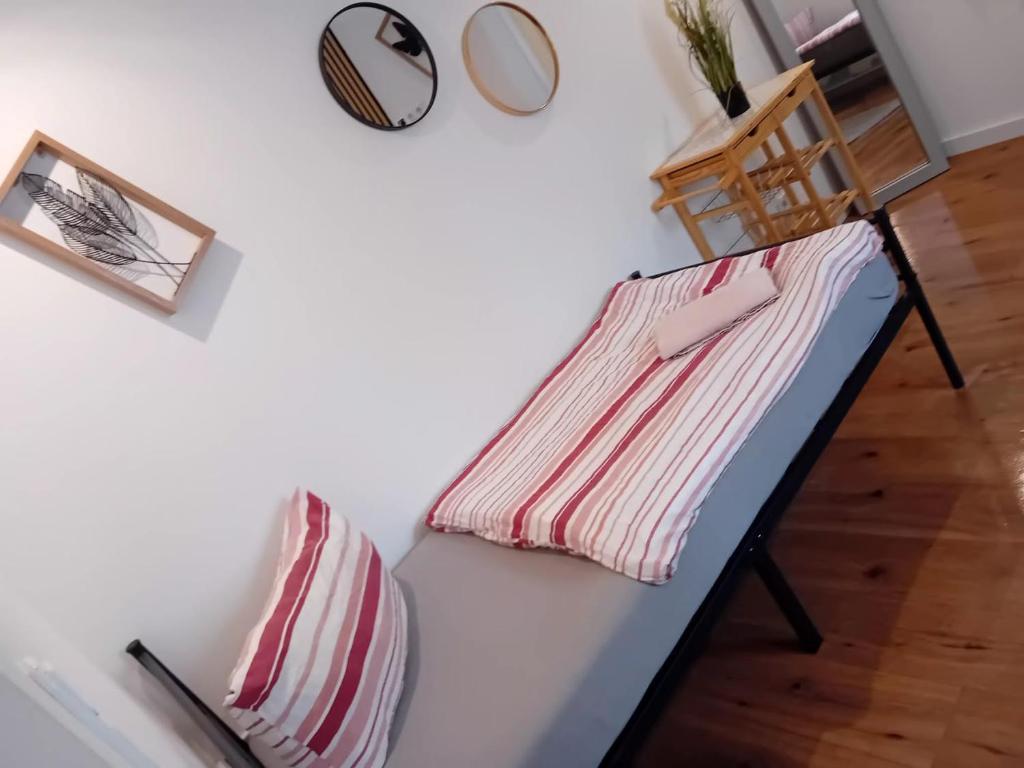 a bed with a striped pillow and a mirror on a wall at Stellas Monteurwohnung in Crimmitschau