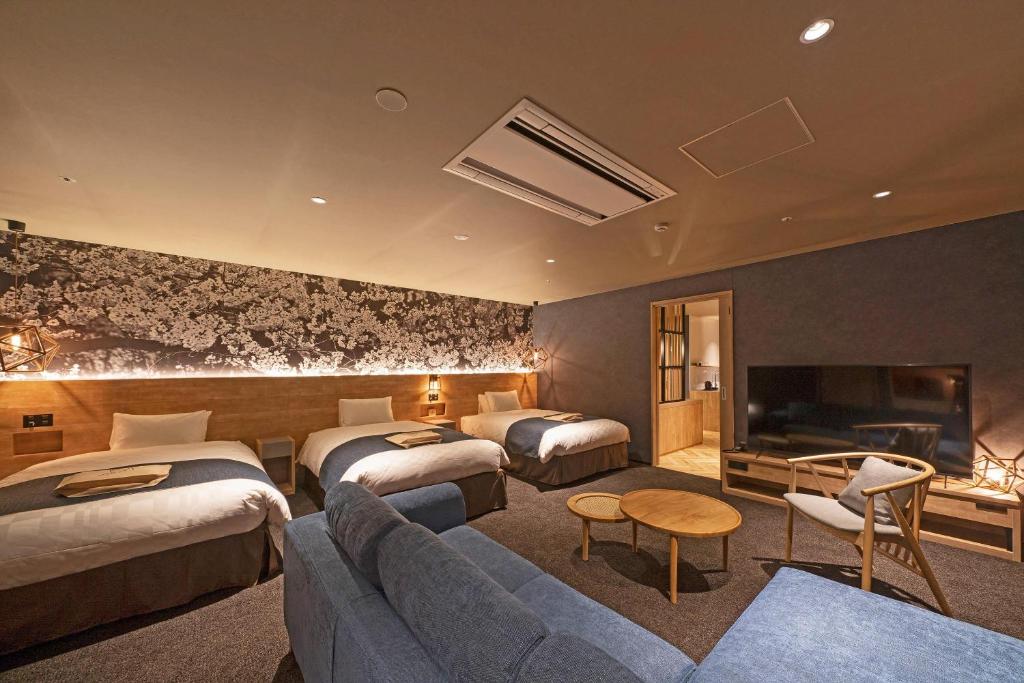 a hotel room with two beds and a couch at hotel around TAKAYAMA, an Ascend Collection Hotel in Takayama