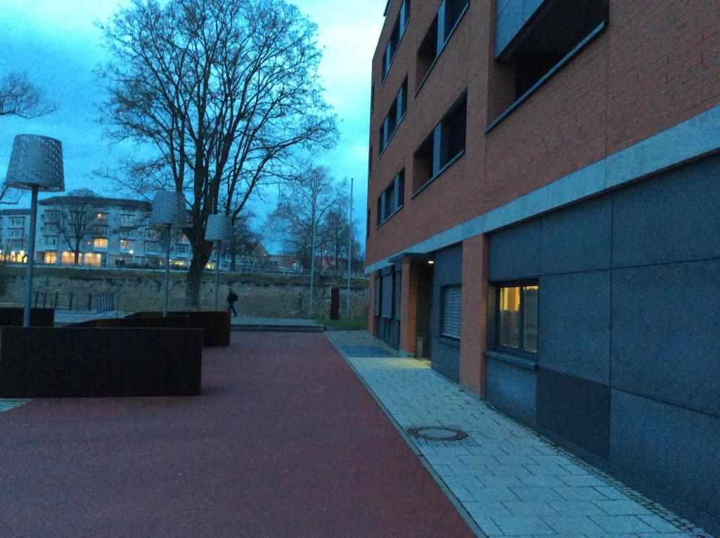 a brick building with a tree next to a building at Schönste Donaulage mit Terrasse 2 in Neu Ulm